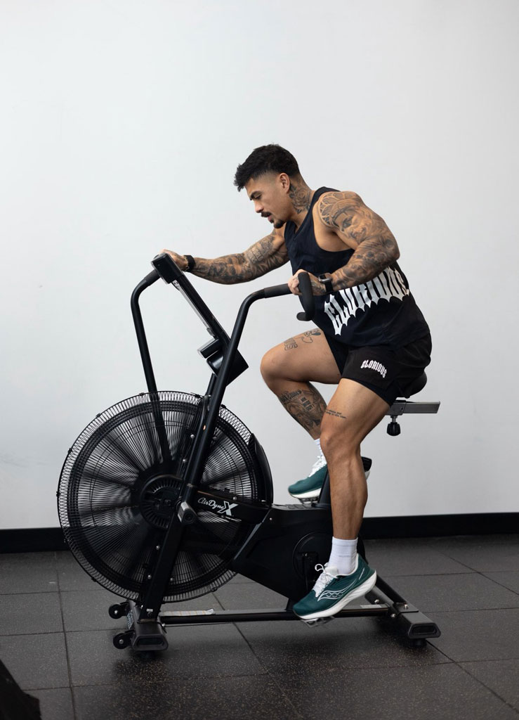 Coach is working out with a bike in the gym.